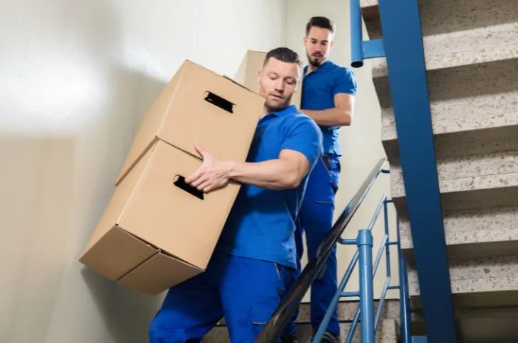 Movers carry boxes down the stairs